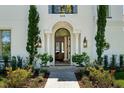 Grand entrance with an arched doorway, decorative columns, and manicured landscaping at 808 Golfpark Dr, Celebration, FL 34747