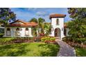 Beautiful Mediterranean-style home with red tile roof, white stucco walls, and landscaped front yard at 8437 Lake Burden Cir, Windermere, FL 34786