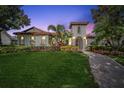 Charming mediterranean home with arched entry, manicured lawn, and colorful flower beds at 8437 Lake Burden Cir, Windermere, FL 34786