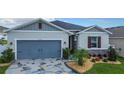 Charming single-Gathering home with a blue garage door, stone accents, and decorative landscaping at 9158 Elsa Ct, Davenport, FL 33897