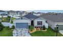 Charming single-Gathering home with a blue garage door, stone accents, and decorative driveway at 9158 Elsa Ct, Davenport, FL 33897