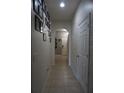 Hallway with light tile flooring and white brick accent wall that leads to the front door at 1217 Honey Blossom Dr, Orlando, FL 32824