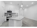 Bright kitchen boasts white cabinetry, stainless steel appliances, and pendant lighting at 10287 Ebb Tide Lane, Orlando, FL 32821