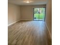 Bright living room with wood-look flooring and a sliding glass door to the outside at 145 Scottsdale Sq # 145, Winter Park, FL 32792