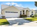 Well-maintained home with a two-car garage and a manicured front lawn at 16014 Hawk Hill St, Clermont, FL 34714