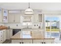 Kitchen with granite counters, a center island, stainless steel appliances, and backyard views at 16035 Wilkinson Dr, Clermont, FL 34714