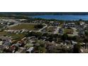 Wide aerial shot showing a neighborhood near a lake, with visible roads and commercial areas at 1756 Elbert Acres Ne Ct, Winter Haven, FL 33881