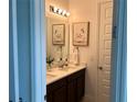 Bathroom featuring double sinks, decorative mirrors, and elegant fixtures at 1767 Smarts Rule St, Kissimmee, FL 34744