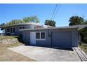 Rear exterior view of a home featuring a garage, backyard access, and well-maintained siding at 2326 S Peninsula Dr, Daytona Beach, FL 32118
