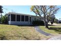 Charming single-story home featuring a screened porch and well-maintained lawn with mature trees at 2326 S Peninsula Dr, Daytona Beach, FL 32118