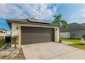 Two-car garage of single-Gathering home with decorative lights and solar panels at 2822 Moultrie Creek Dr, Kissimmee, FL 34743