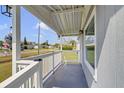 Covered front porch with white wooden pillars and railings, offering a peaceful outdoor space at 3139 Morning Light Way, Kissimmee, FL 34744