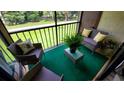 Cozy screened balcony with seating and a view of the green lawn and surrounding trees at 3214 Candle Ridge Dr # 201, Orlando, FL 32822