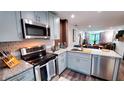 Modern kitchen with stainless steel appliances, granite countertops, and gray shaker cabinets at 3214 Candle Ridge Dr # 201, Orlando, FL 32822