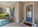 Inviting porch with blue accents, comfortable seating, and a decorative front door at 3317 Schoolhouse Rd, Harmony, FL 34773