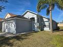 Traditional exterior with a clean white garage door, neutral paint, manicured lawn, and attractive landscaping at 334 Sonja Cir, Davenport, FL 33897