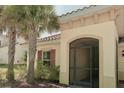 Charming home entrance with mature palm trees and an arched screened entry door at 3818 Carrick Bend Dr, Kissimmee, FL 34746