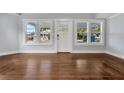Bright living room with hardwood floors, white trim, and three front windows with ample natural light at 415 S 9Th St, Leesburg, FL 34748