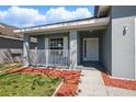 Charming front porch featuring white railings and colorful landscaping at 4411 Great Harbor Ln, Kissimmee, FL 34746