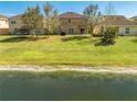 Expansive backyard with lush green grass, mature trees, and a serene waterfront view at 4842 Rockvale Dr, Kissimmee, FL 34758