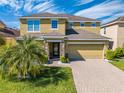 Charming two-story home featuring a brick driveway and verdant lawn creating a warm and inviting curb appeal at 4842 Rockvale Dr, Kissimmee, FL 34758
