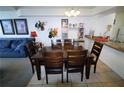 A dining area with a table for six with artwork on the walls and bar seating adjacent to the kitchen at 5004 Laguna Bay Cir # 54, Kissimmee, FL 34746