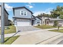 Exterior view of a two-story home with a well-maintained lawn and paved driveway at 6592 Taxiway Cir, Orlando, FL 32822