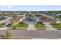 Neighborhood aerial view of a charming single-story home with solar panels, a stone accent, and a well-manicured lawn at 669 Persian Dr, Haines City, FL 33844