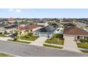 Neighborhood aerial view of a charming single-story home with solar panels, a stone accent, and a well-manicured lawn at 669 Persian Dr, Haines City, FL 33844