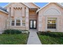 Close-up of the front entrance with double doors and manicured landscaping at 673 Leland Dr, Deltona, FL 32725