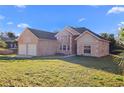 Brick home exterior showcasing the front lawn and attached two-car garage at 673 Leland Dr, Deltona, FL 32725