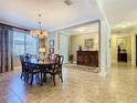 Elegant dining room featuring a large table, chandelier, and open access to the living areas at 759 Villa Park Rd, Poinciana, FL 34759