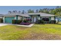 Charming single-story home with a manicured lawn and garden beds full of lush, colorful landscaping at 7794 Indian Ridge S Trl, Kissimmee, FL 34747