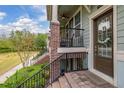 Inviting front porch with brick stairs, black railing, a cozy seating area, and a decorated front door at 840 Luarca Ln, Oviedo, FL 32765