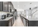 Modern kitchen with sleek cabinets, stainless steel appliances, and an open view to the dining area at 8968 Amelia Downs Trl, Kissimmee, FL 34747