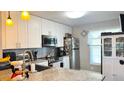 Well-appointed kitchen with white cabinetry, granite countertops, and stainless steel appliances at 13840 Timberbrooke Dr # 103, Orlando, FL 32824