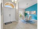 Bright dining room with modern glass table set, accented by an elegant light fixture and tiled floors at 152 Moscato Dr, Davenport, FL 33897