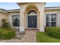 Close up of home entrance with inviting double doors and a brick walkway at 152 Moscato Dr, Davenport, FL 33897