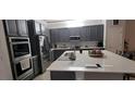 Modern kitchen with stainless steel appliances, ample counter space, and stylish gray cabinetry at 17880 Passionflower Cir, Clermont, FL 34714