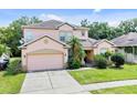 Charming two-story home with a well-manicured lawn and attached two-car garage at 2165 The Oaks Blvd, Kissimmee, FL 34746