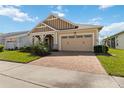 Charming one-story home with a brick paver driveway, two-car garage, and lush green lawn at 2658 Meadowedge Loop, St Cloud, FL 34772