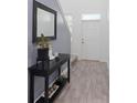 Stylish entryway with wood-look tile flooring, console table with decor, and plenty of natural light at 2724 Camden Ln, Davenport, FL 33837