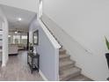 Entryway leading to a carpeted staircase and open-concept living space with wood-look tile at 2724 Camden Ln, Davenport, FL 33837