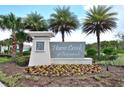 Beautiful entrance sign to Horse Creek at Crosswinds, surrounded by lush tropical landscaping and vibrant floral arrangements at 297 Gina Ln, Davenport, FL 33837