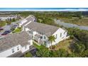 An aerial view of townhouses with lush surroundings, including a serene pond and mature trees at 426 Captiva Dr, Davenport, FL 33896
