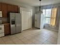 Eat in kitchen area with tile flooring, brown cabinets, and natural light at 4406 Hidden Meadow Dr, Kissimmee, FL 34746