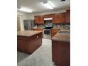 Spacious kitchen featuring an island, stainless steel appliances, and wood cabinets at 4710 Willoughby St, Kissimmee, FL 34758