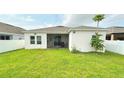 Expansive backyard featuring a well-maintained lawn, screened-in porch, and privacy fence at 486 Disa Dr, Davenport, FL 33837
