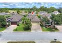 Aerial view of a home with a brick driveway in a residential neighborhood near a lush golf course at 514 Cadiz Dr, Davenport, FL 33837