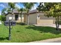Inviting single-story home featuring a manicured lawn, palm trees, and a charming mailbox on a sunny day at 514 Cadiz Dr, Davenport, FL 33837